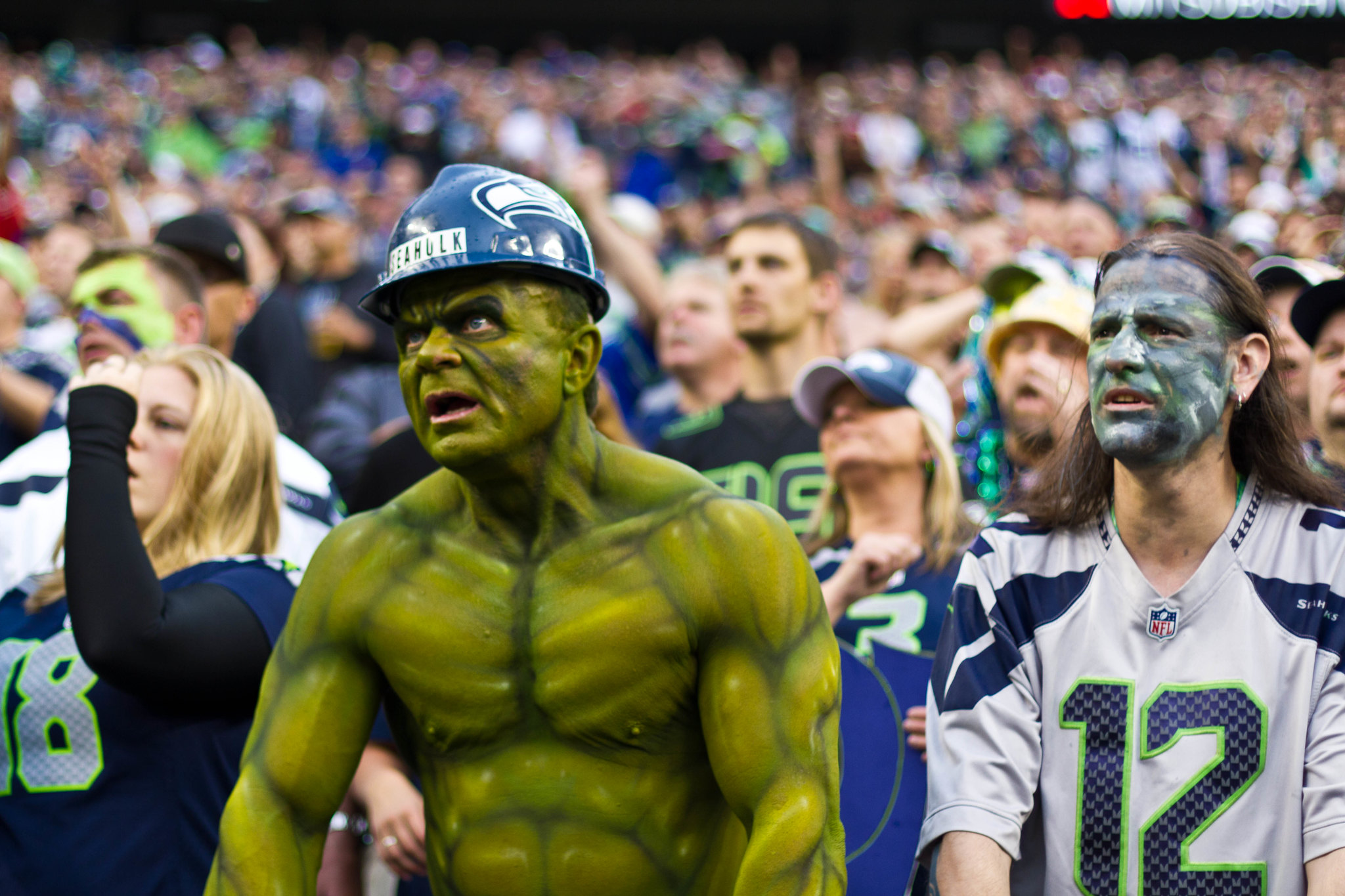 Color photograph of a crowd of football fans, one of whom is dressed up like the Hulk