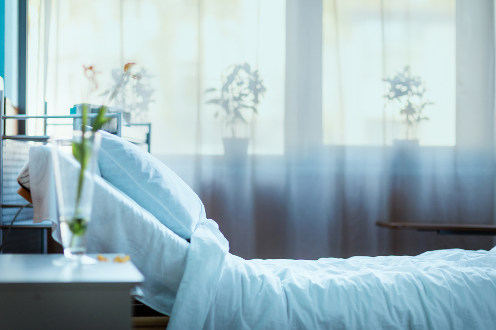 photograph of empty hospital bed with curtains closed