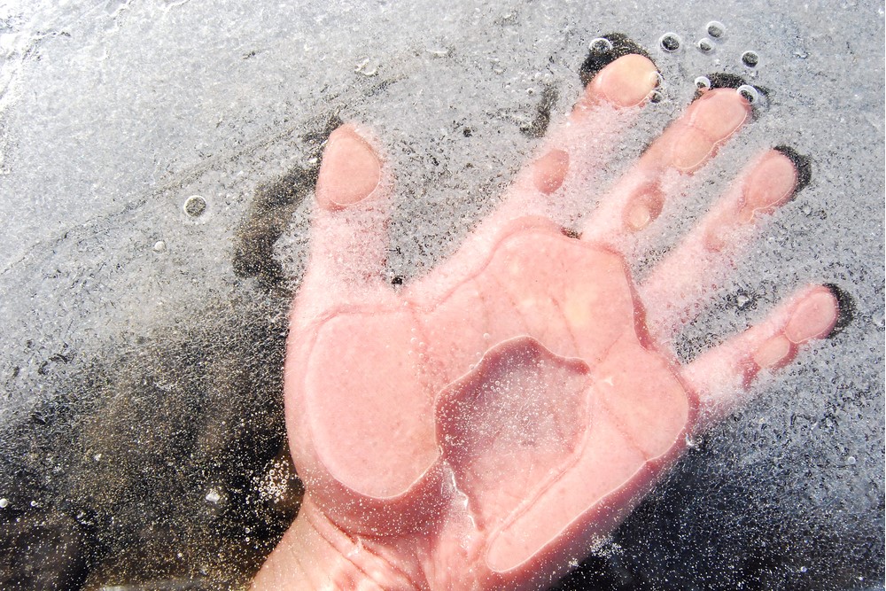 photograph of hand pressed on thawing glass