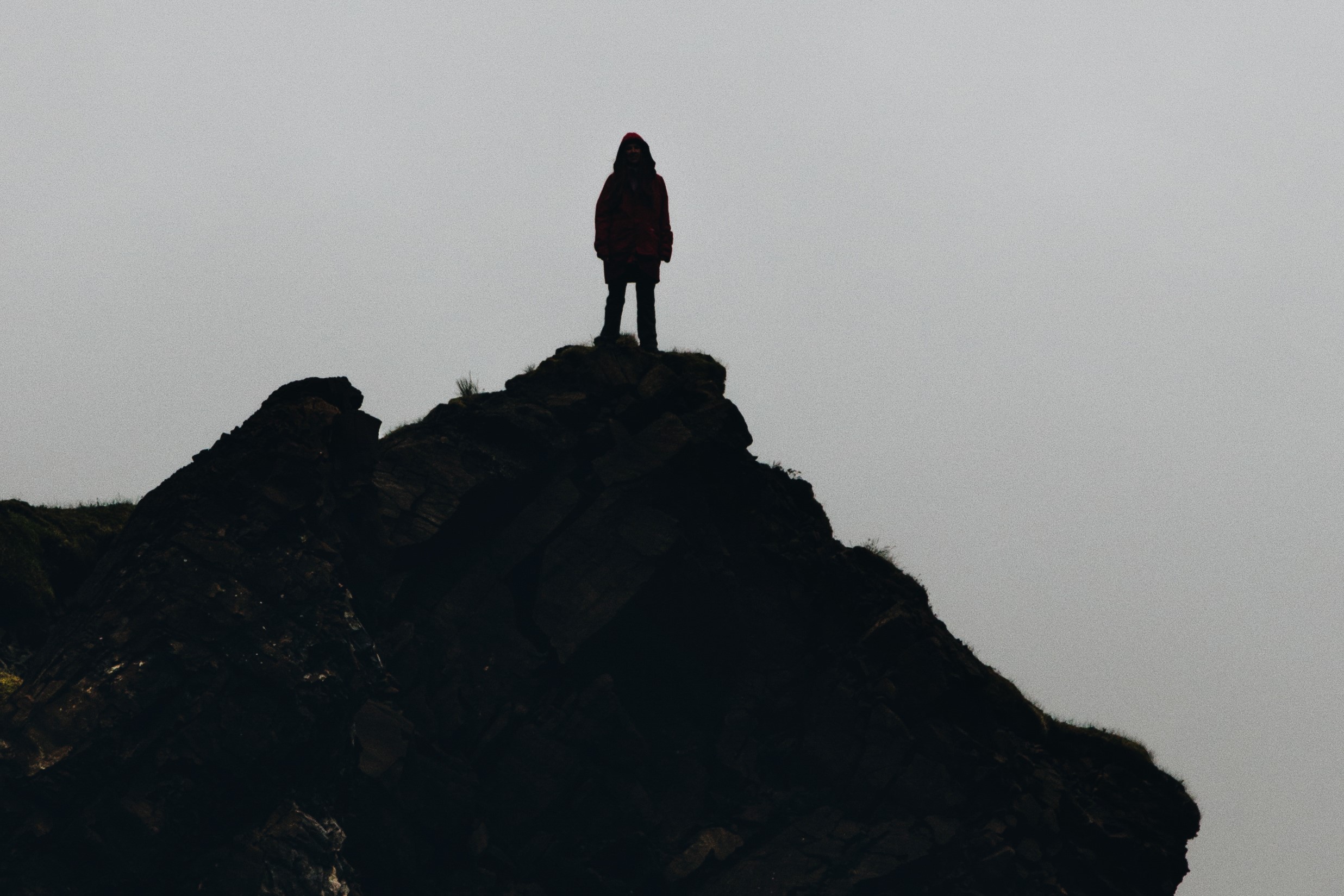 photograph of silhouetted woman on cliff