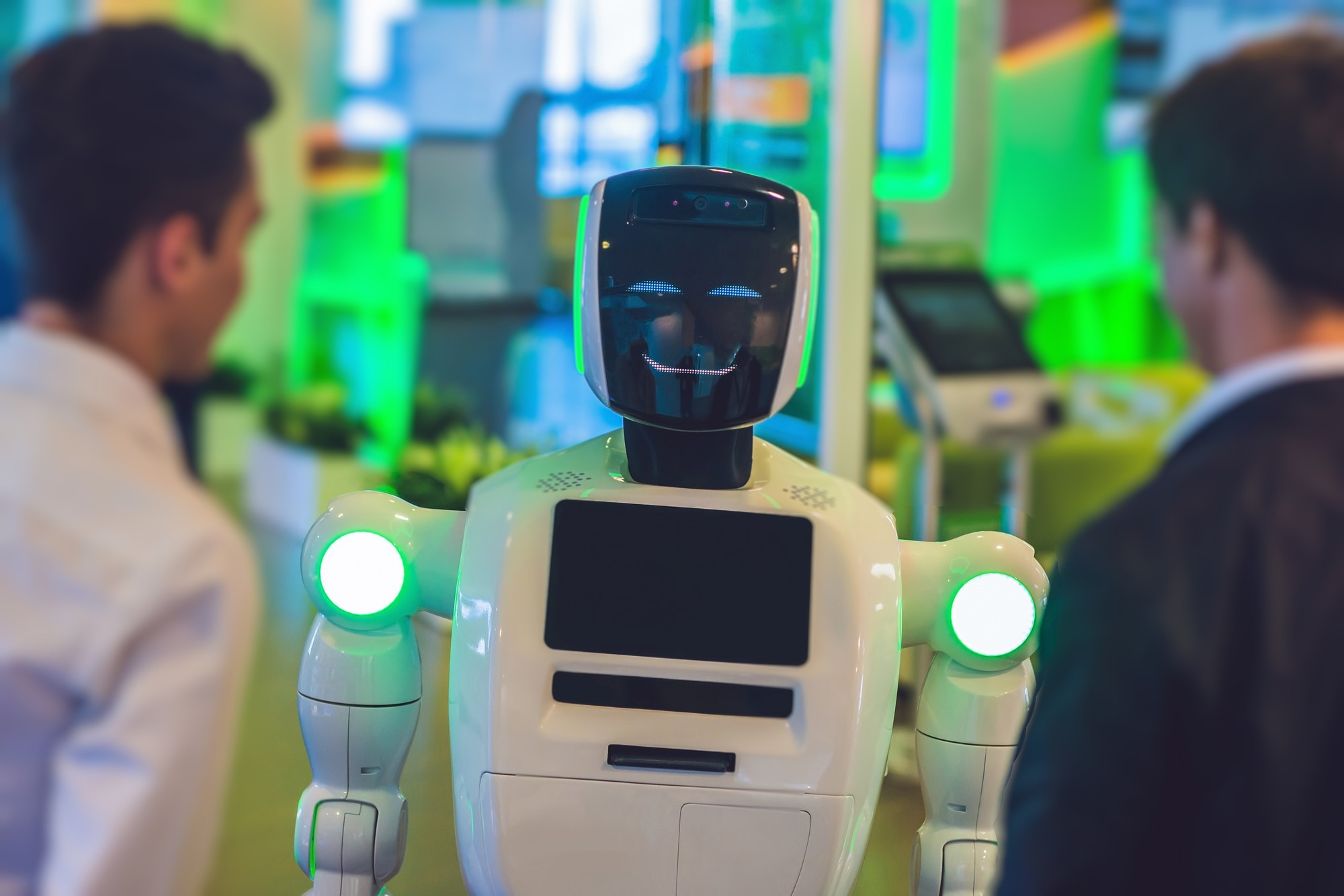 photograph of smiling robot interacting with people at trade show