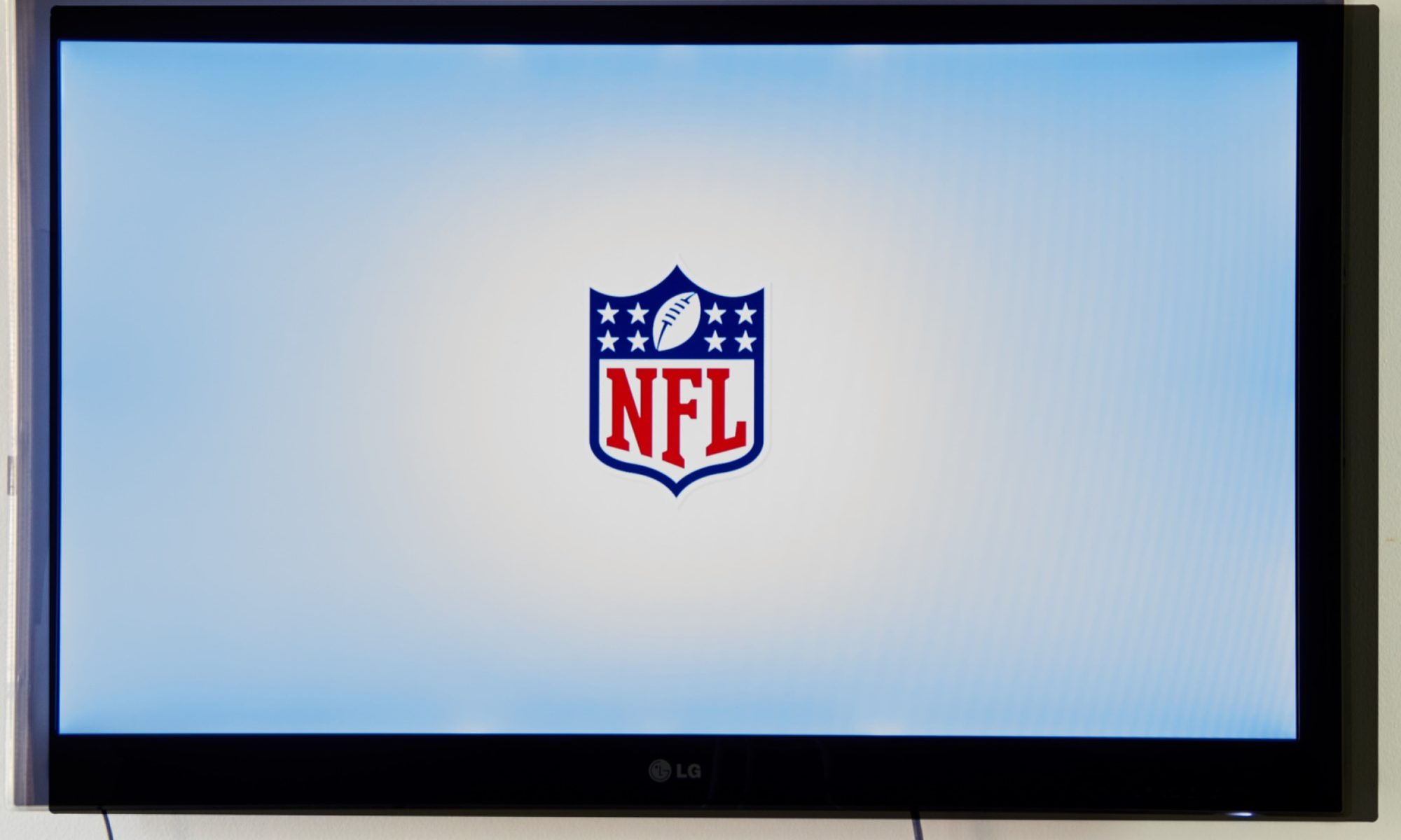 photograph of NFL logo on TV screen