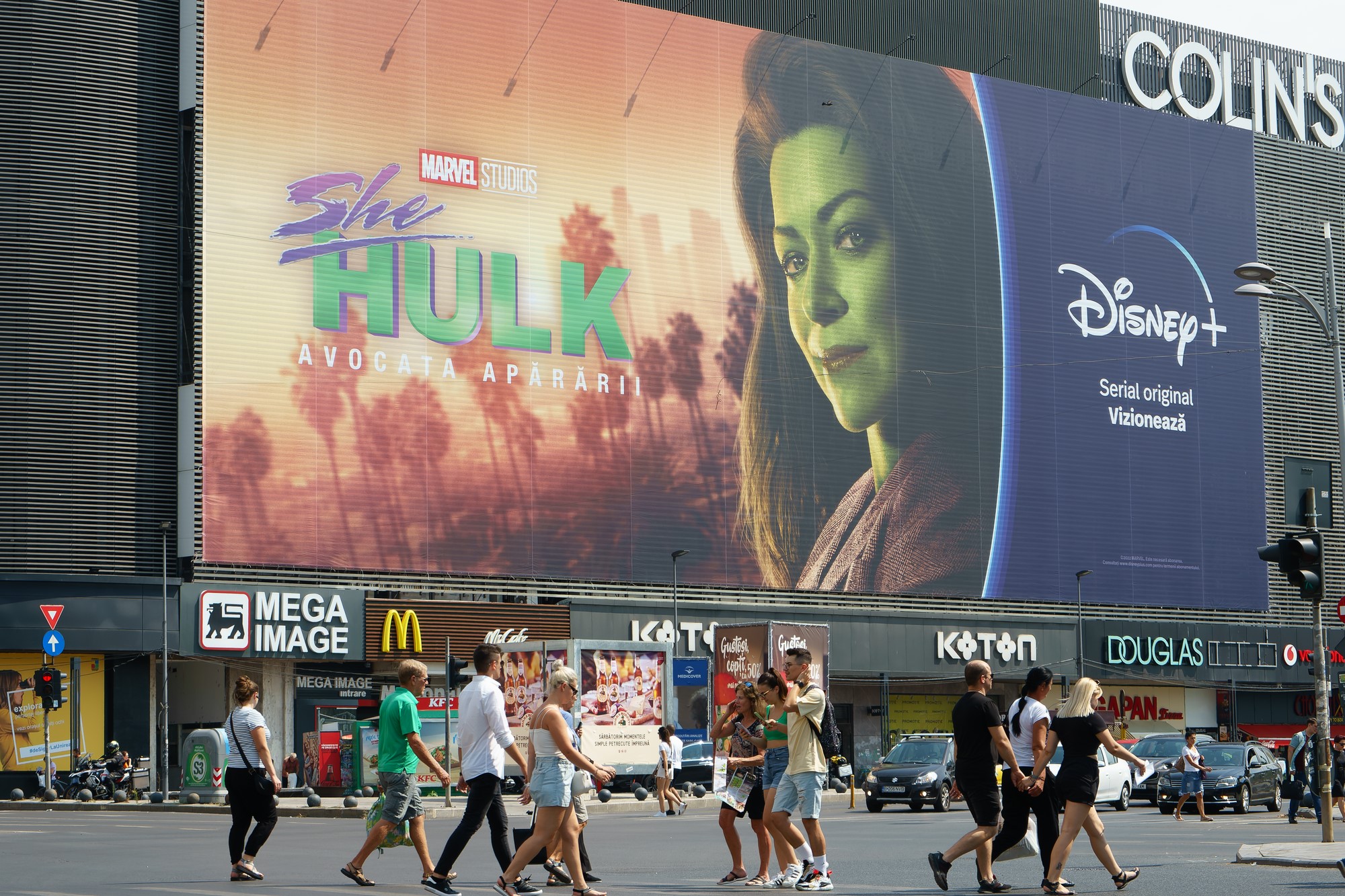 photograph of She-Hulk billboard with crowd walking below