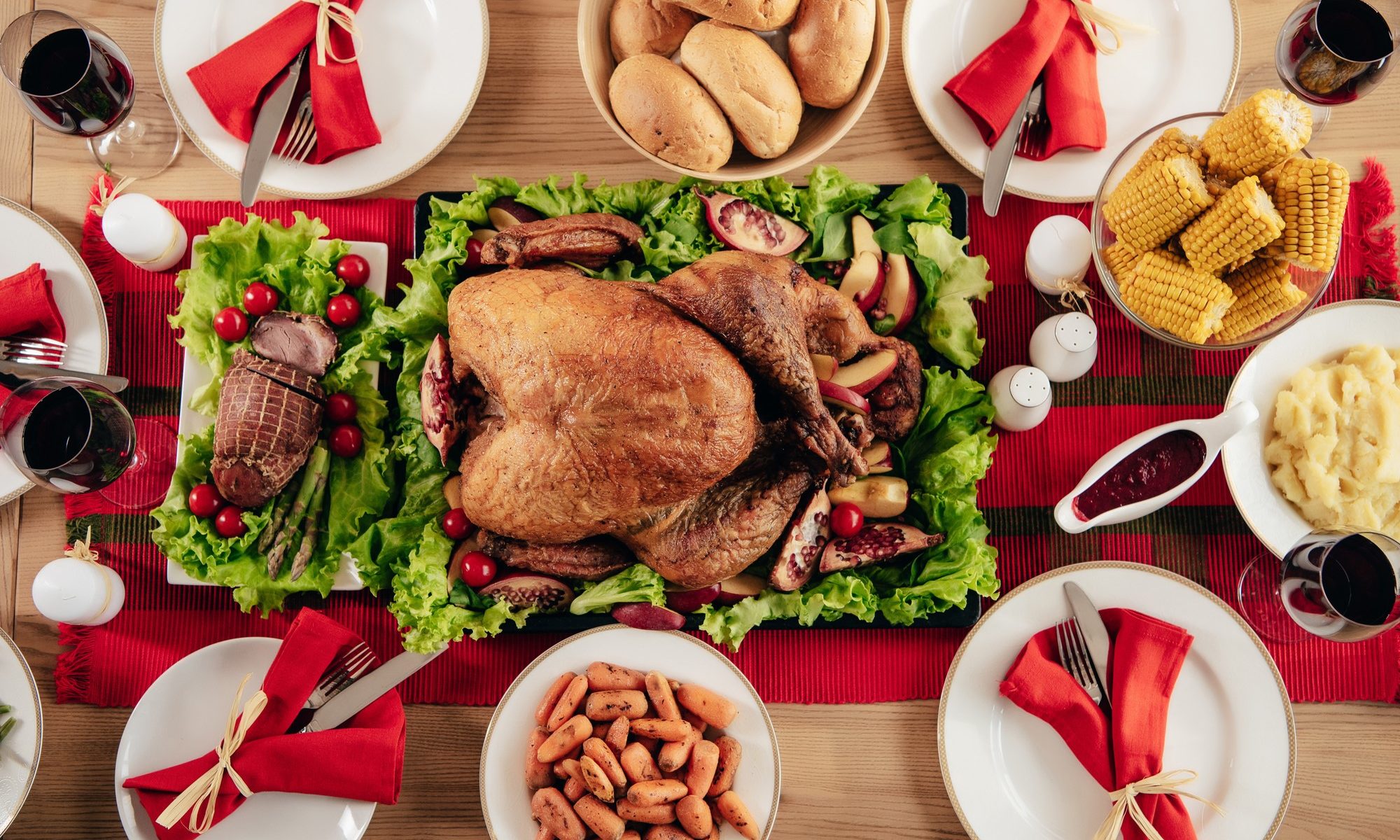top-down photograph of holiday table set with turkey and sides
