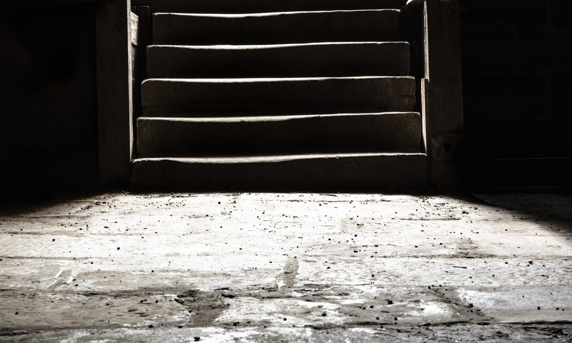 photograph of stone basement floor at bottom of stairs