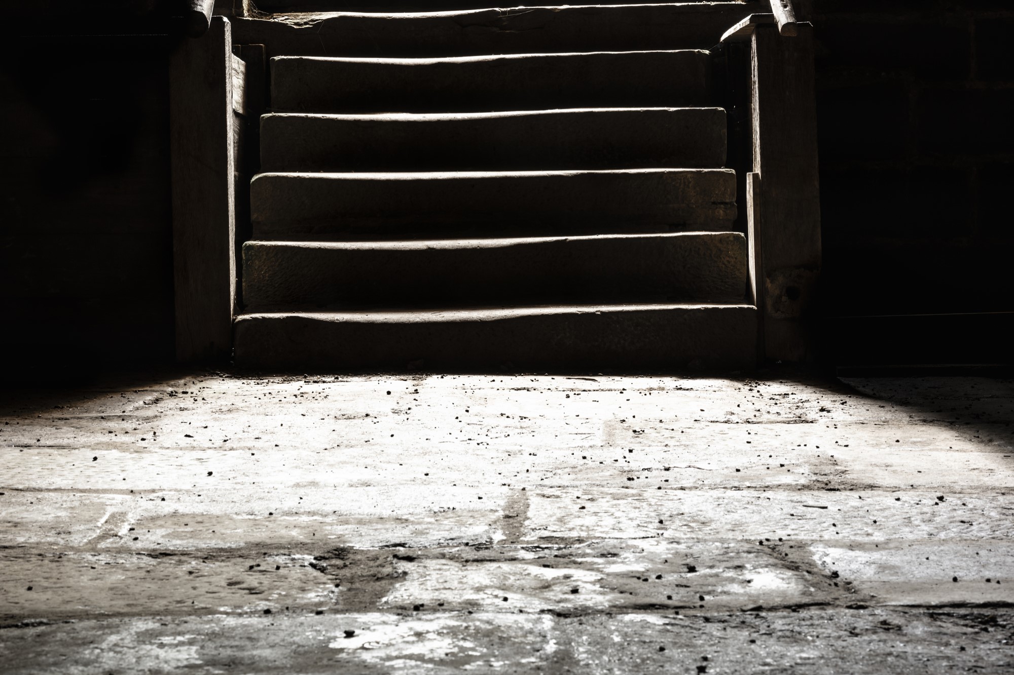 photograph of stone basement floor at bottom of stairs