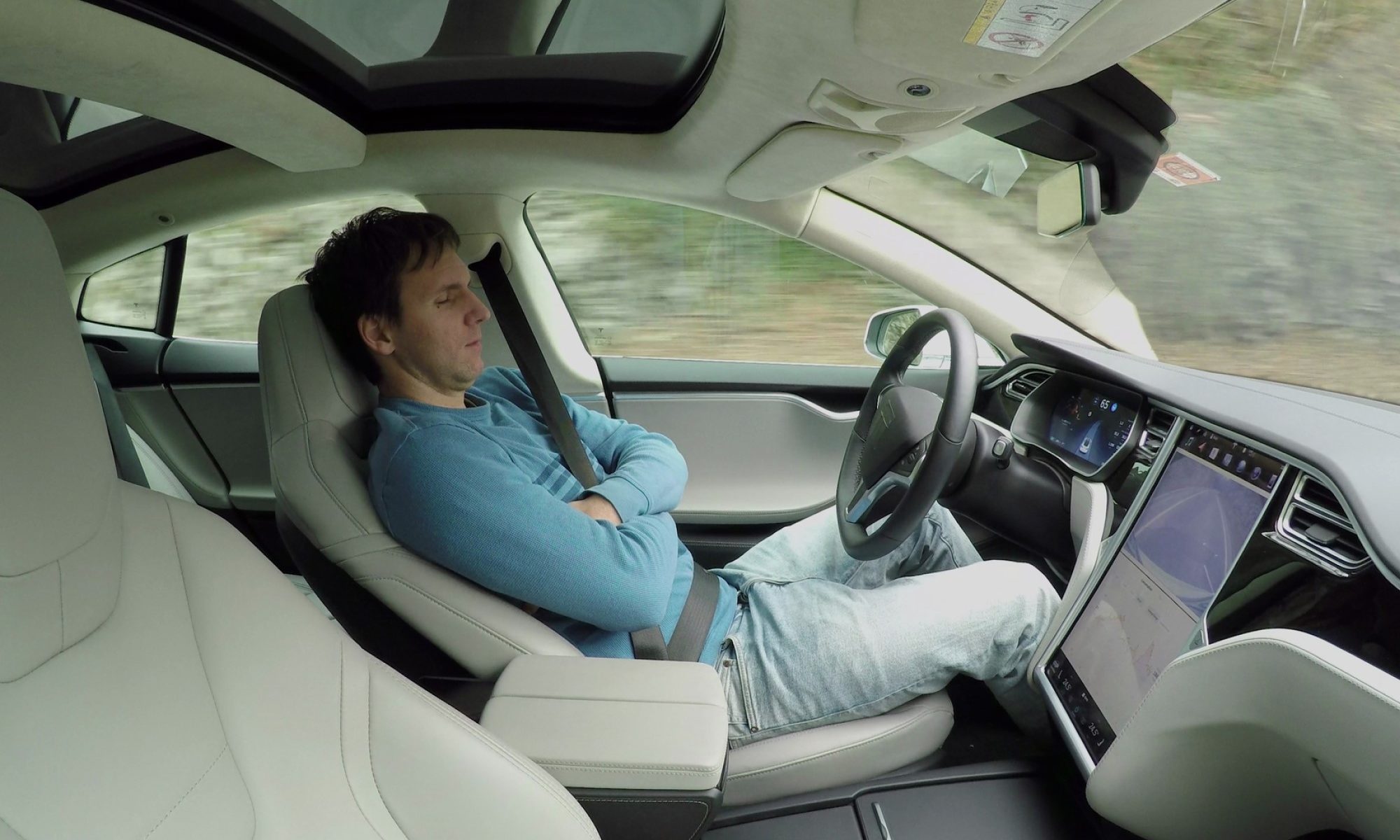 photograph of driver sleeping in self-driving car