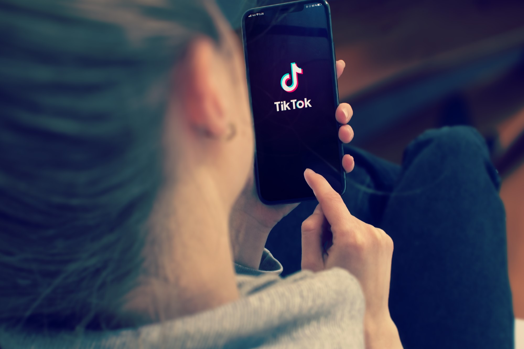 photograph of woman using TikTok on iphone
