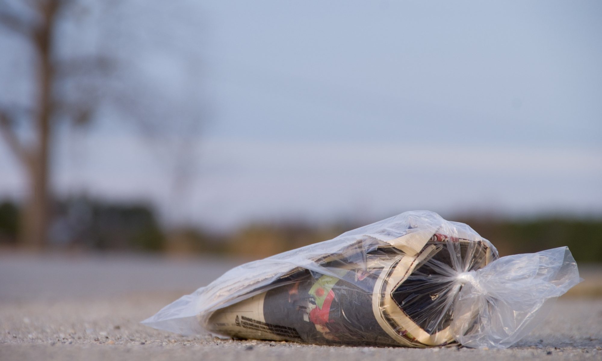 photograph of bagged newspaper abandoned on road