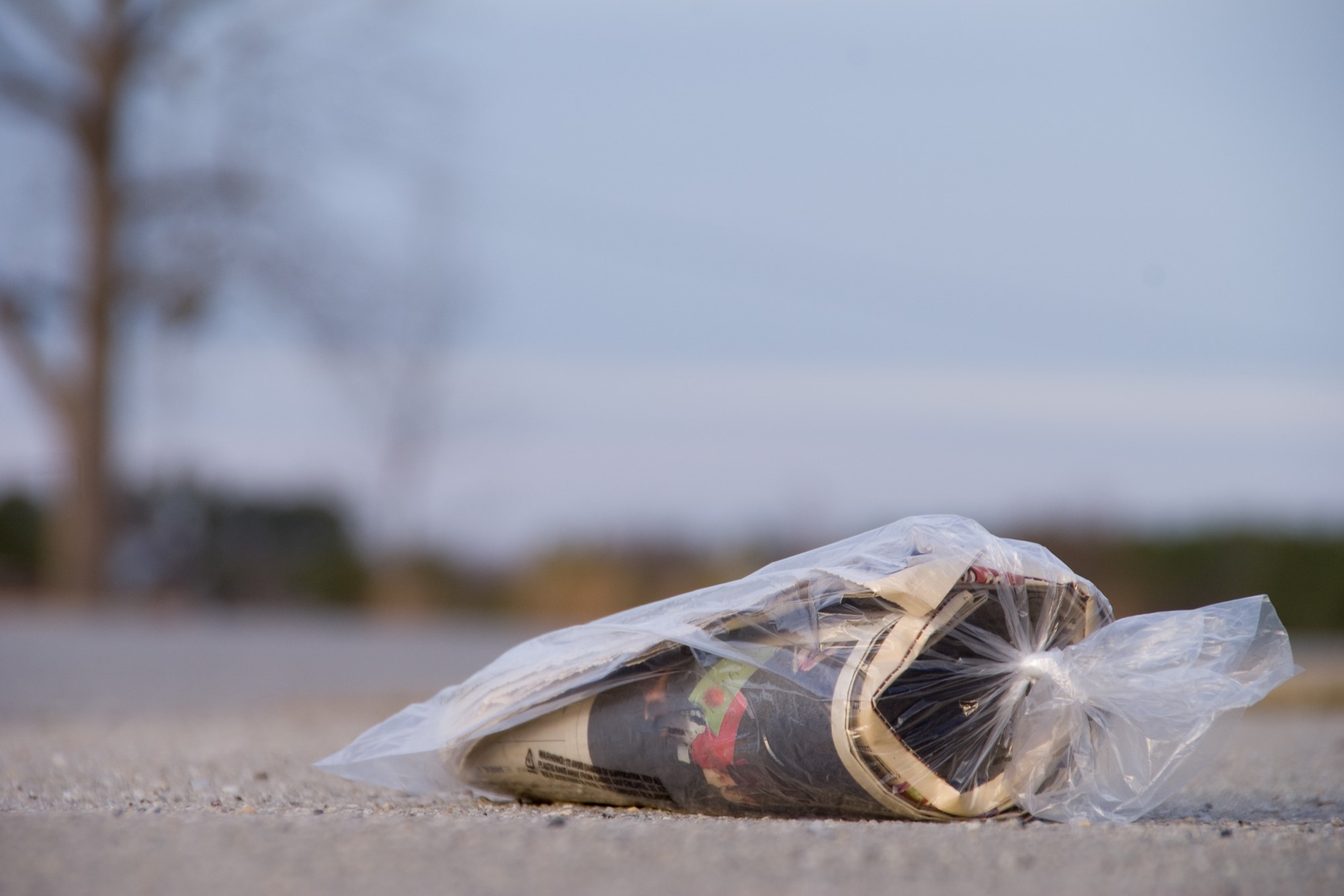 photograph of bagged newspaper abandoned on road