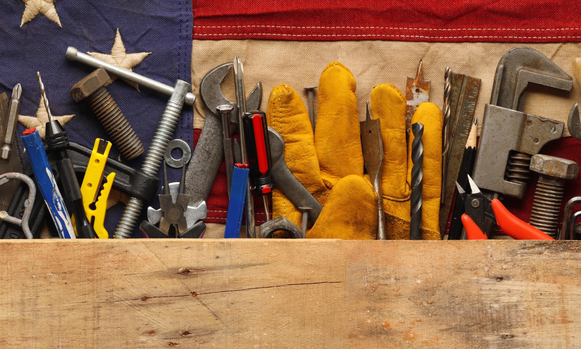 photograph of worker's tools arranged with US flag background