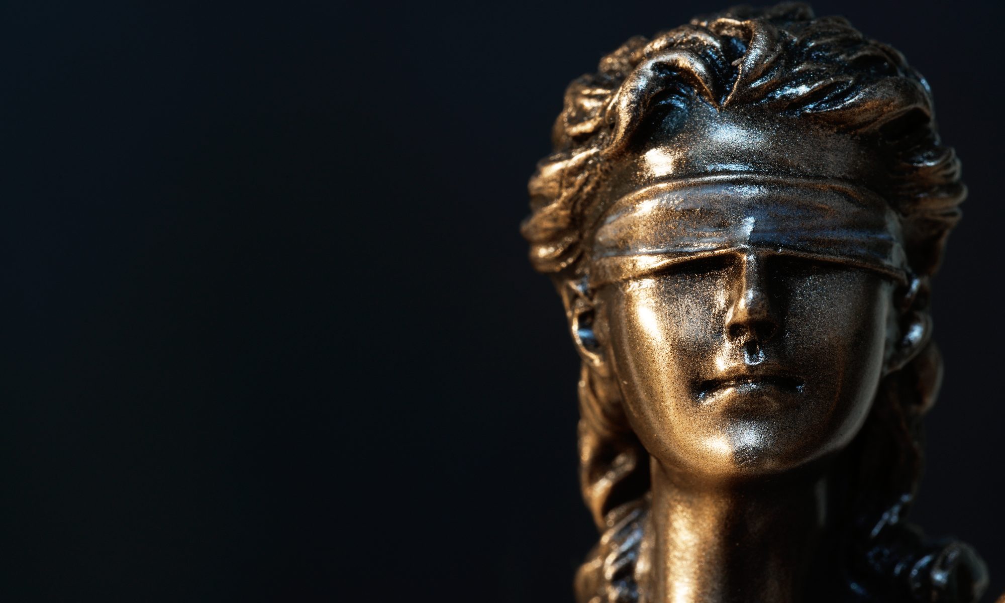 close-up photograph of Lady Justice statue's blindfolded face