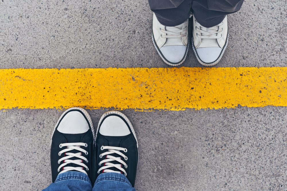 photograph of dividing line with shoes on opposite sides