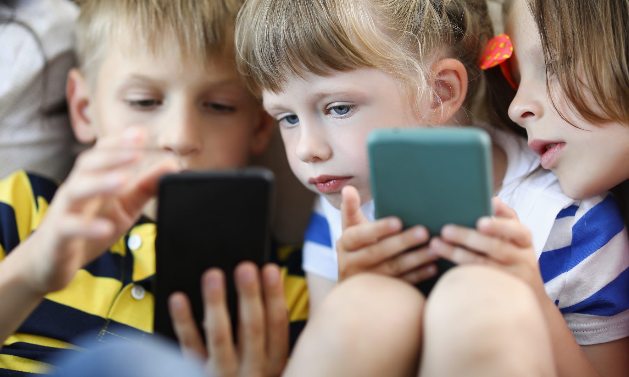 photograph of children playing on smartphone