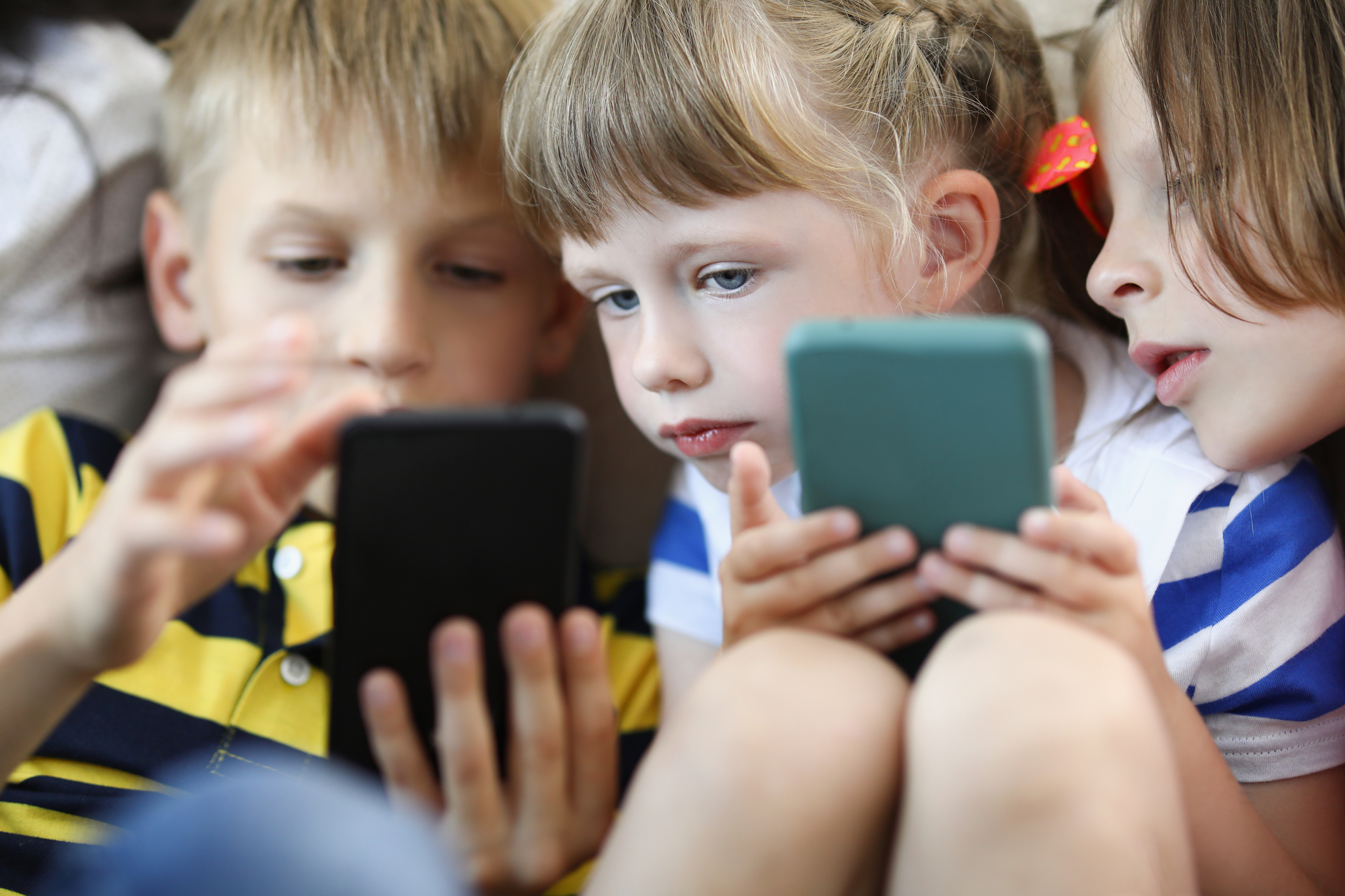 photograph of children playing on smartphone