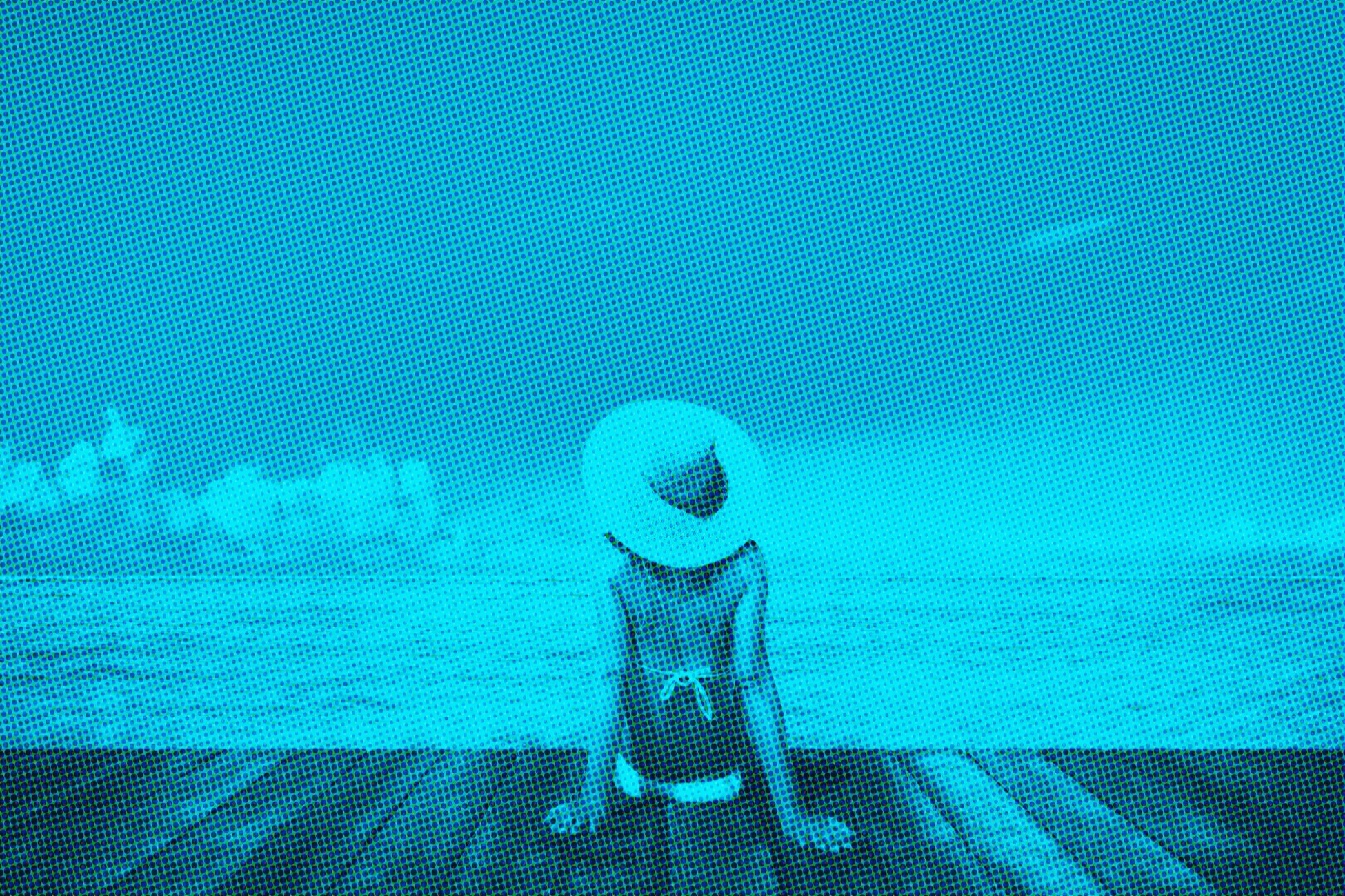 digitized image of woman relaxing on beach dock