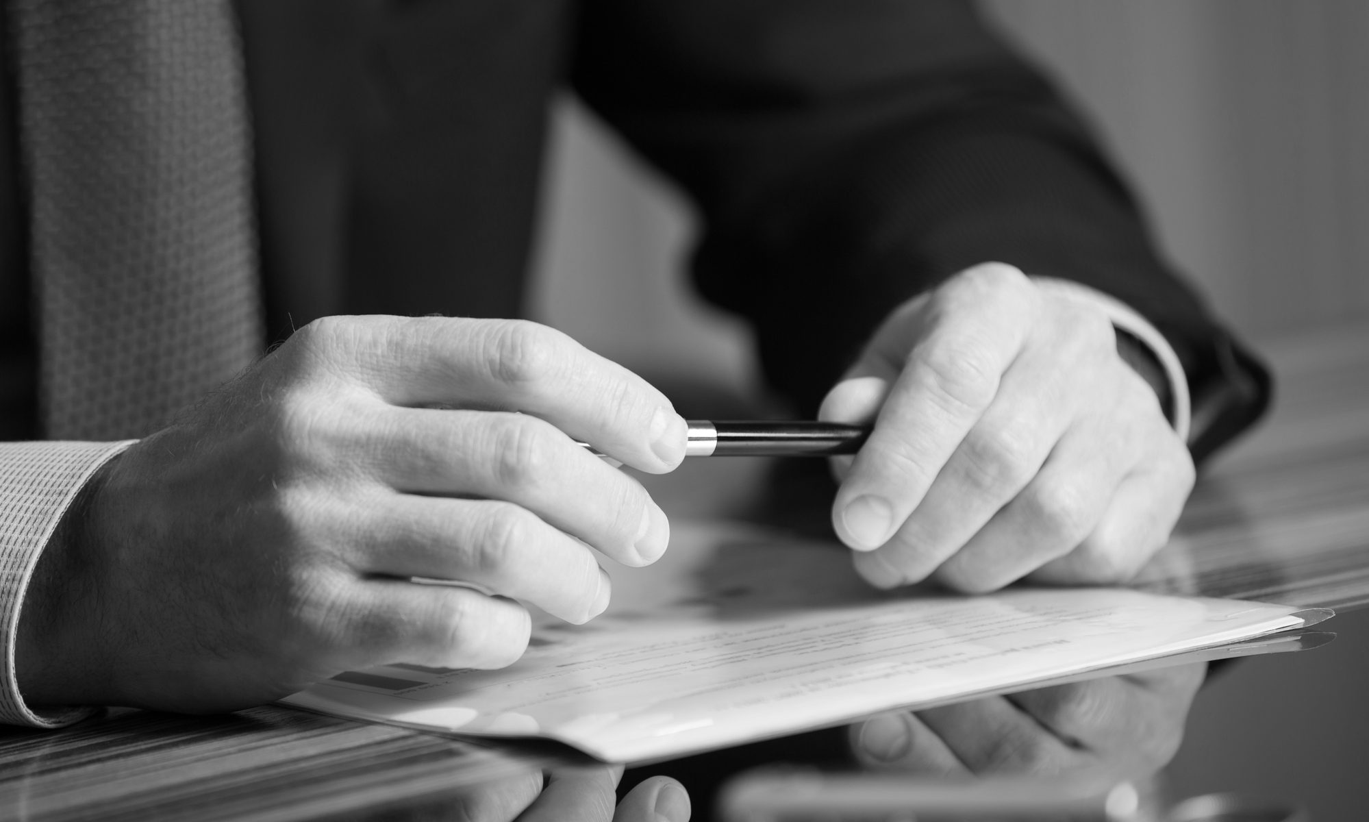 black and white photo of lawyer holding pen and documents