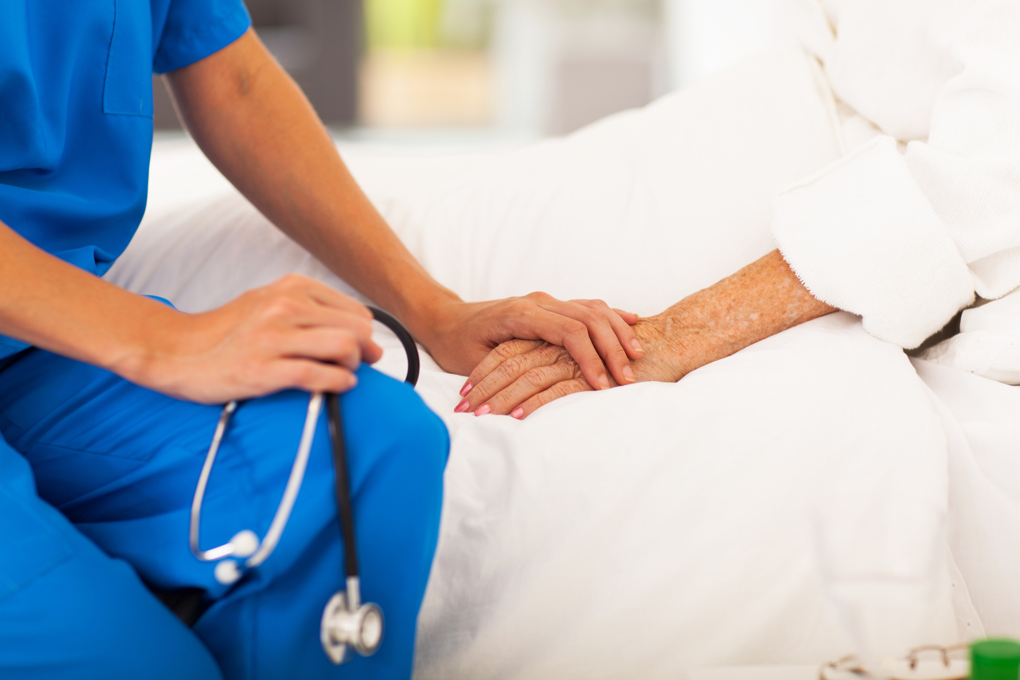 photograph of medical staff holding patients hand