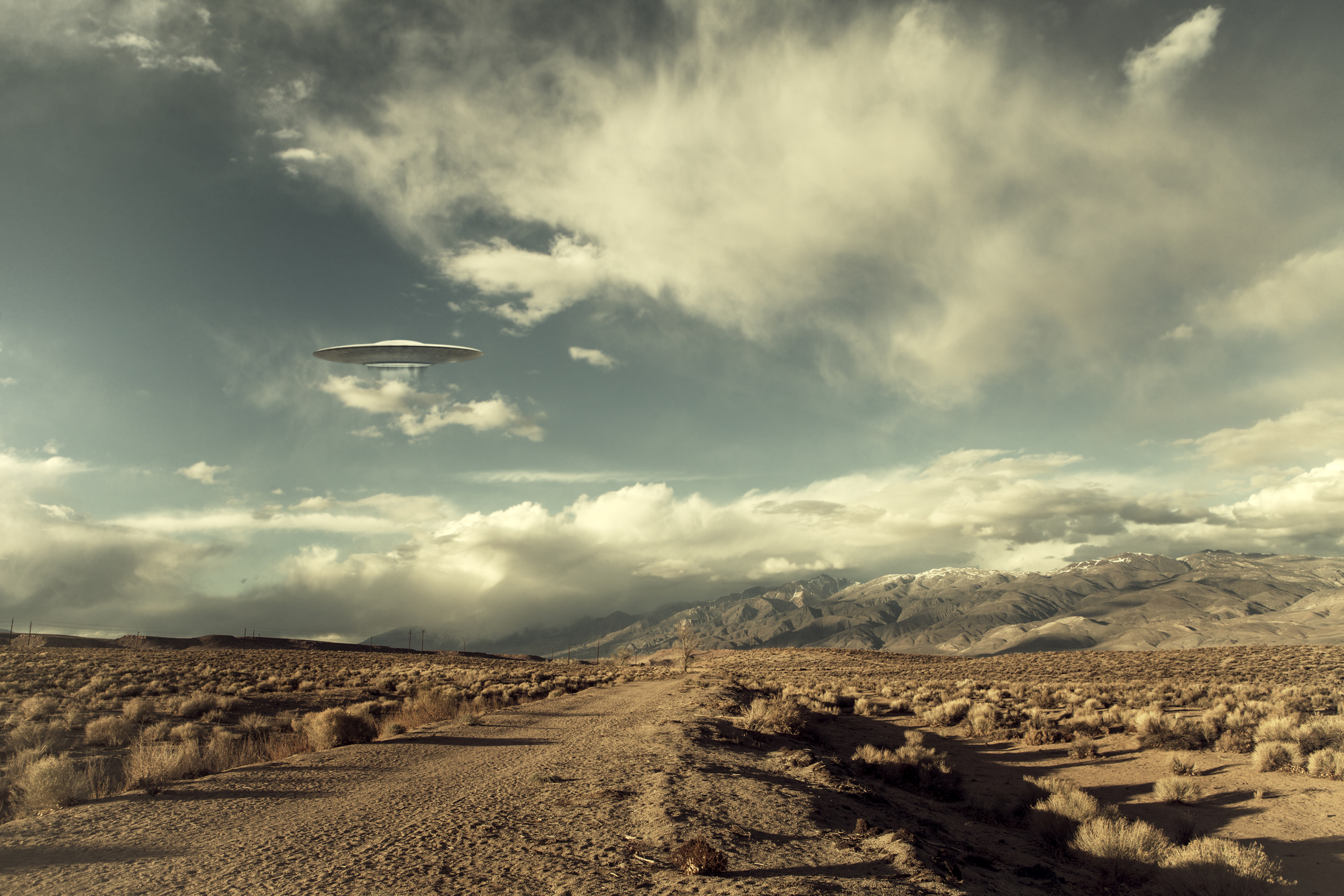image of ufo hovering over desert road