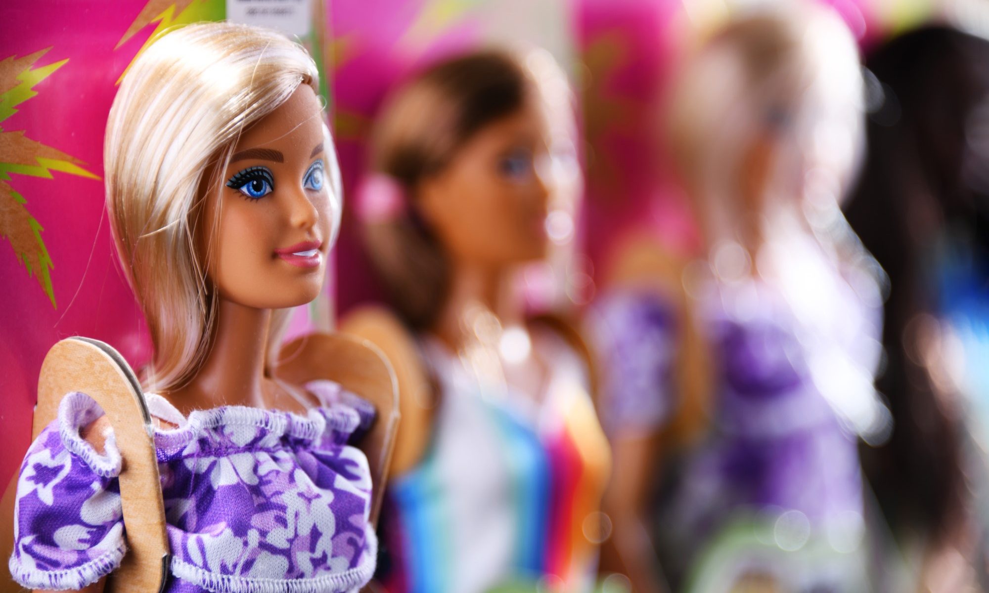 photograph of Barbie dolls in packaging on shelf