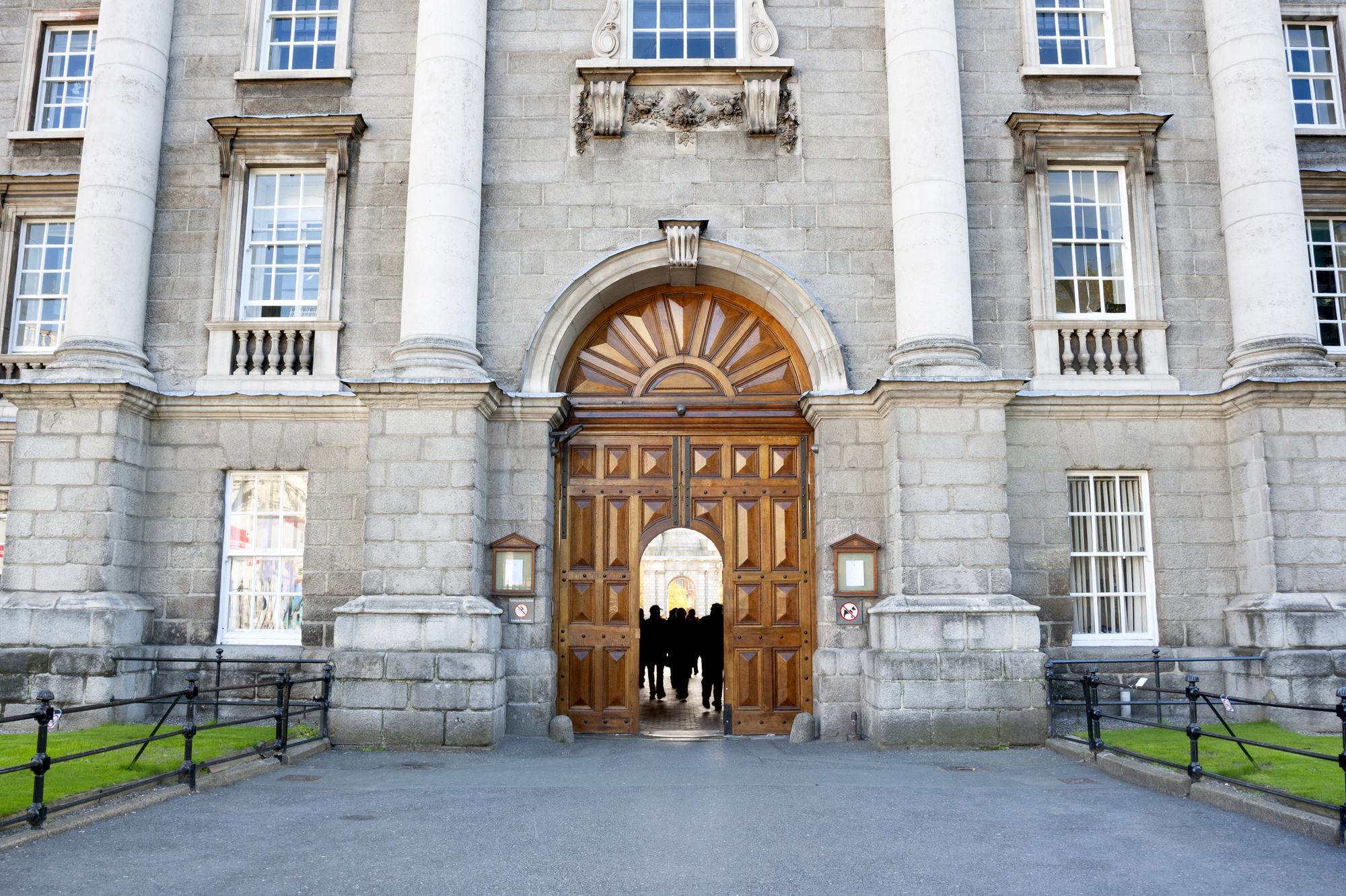 photograph of college gates with students beyond