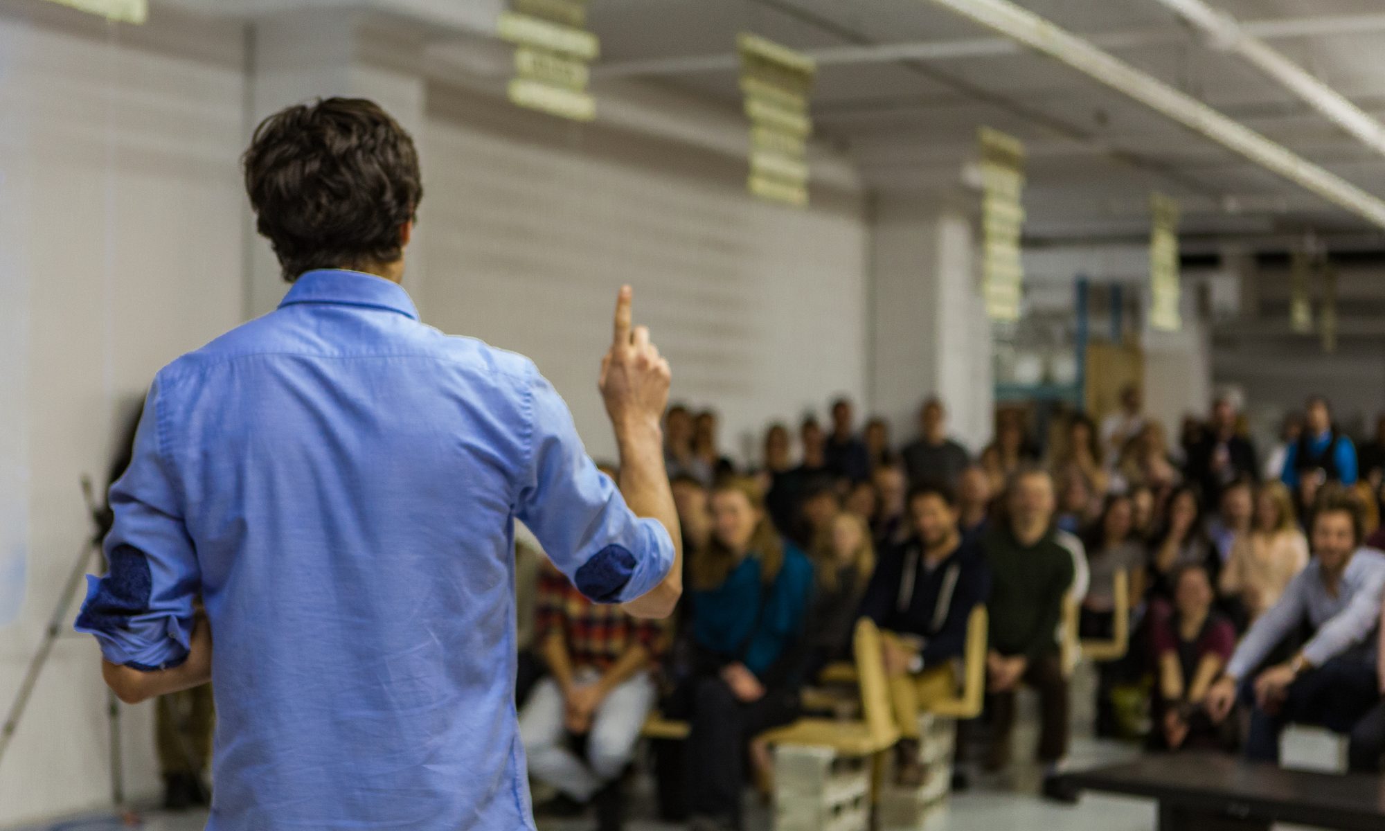 photograph of teacher presenting to packed classroom