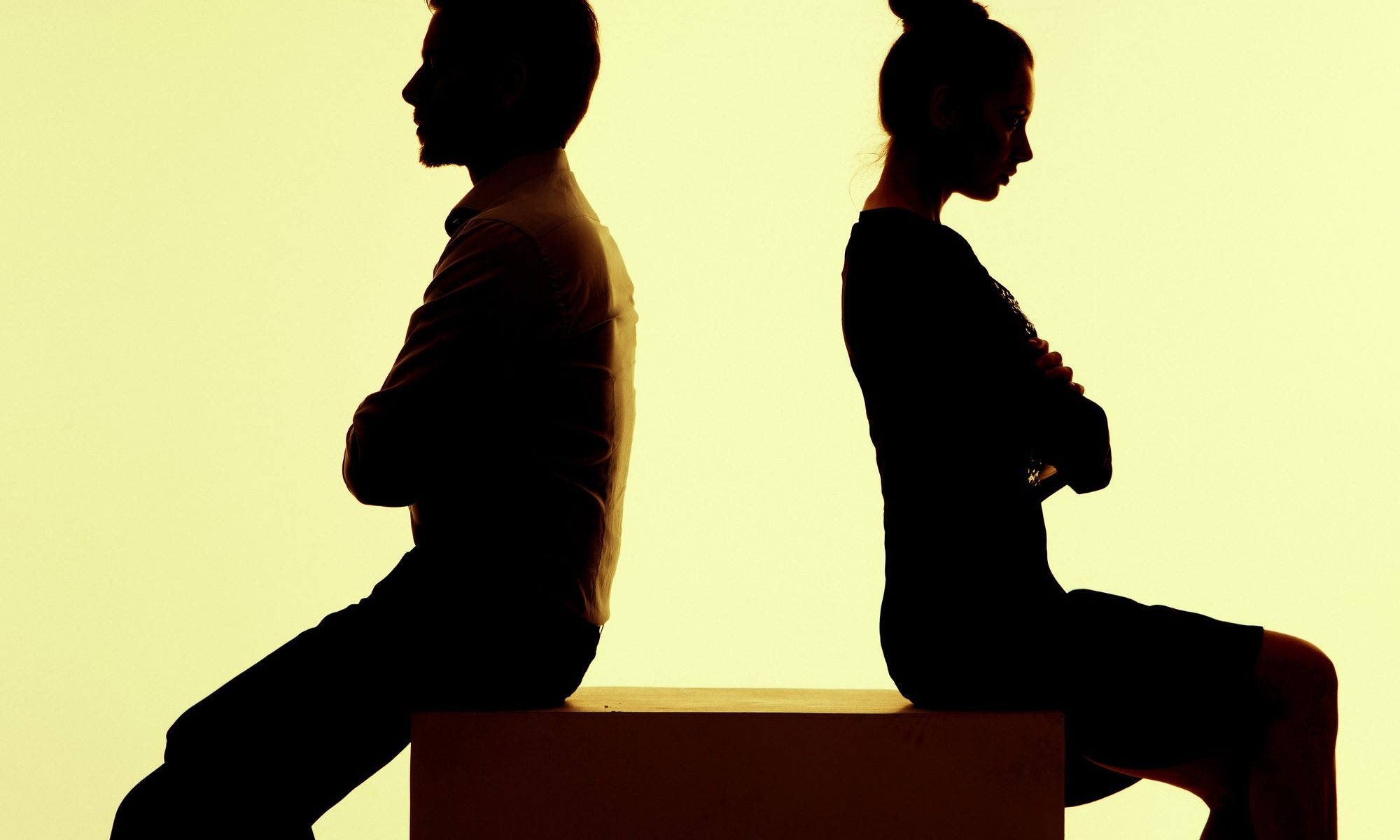 silhouette of man and woman with backs turned to one another