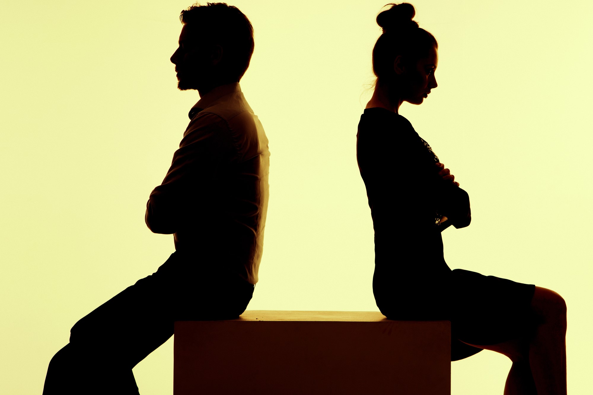 silhouette of man and woman with backs turned to one another