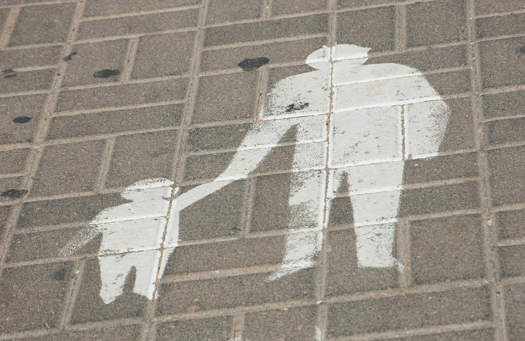 photograph of parent/child pedestrian sign on tile pavement