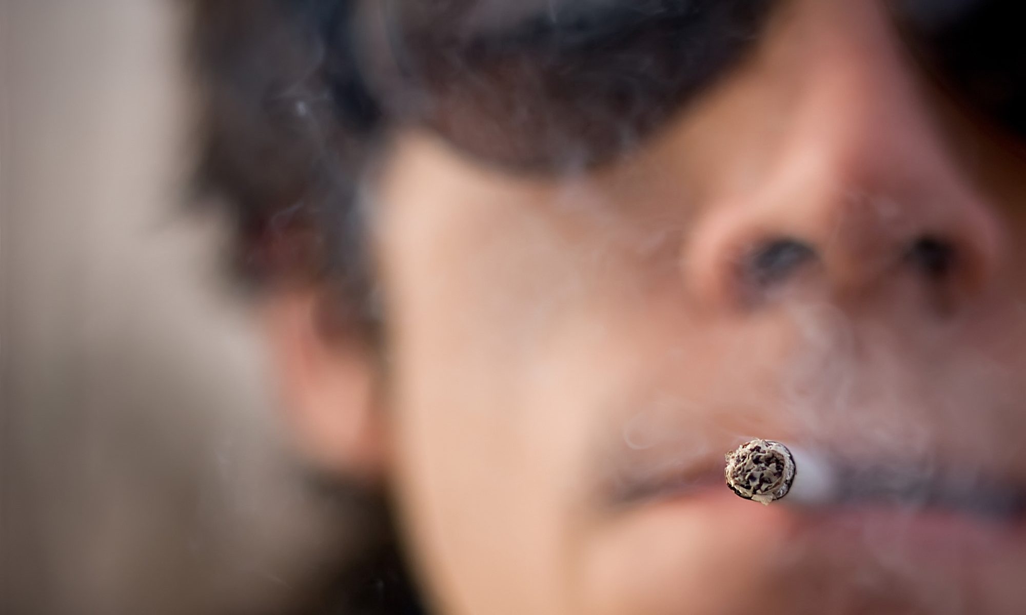 close-up photograph of defiant smoker in sunglasses