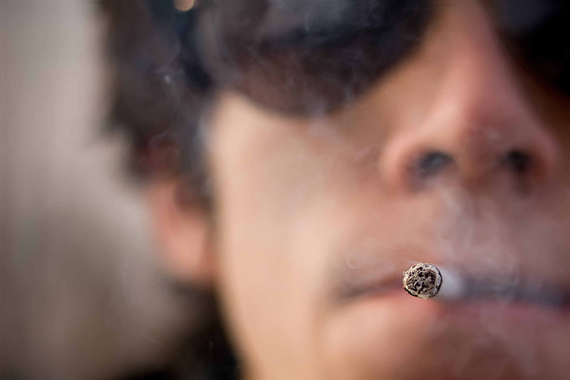 close-up photograph of defiant smoker in sunglasses