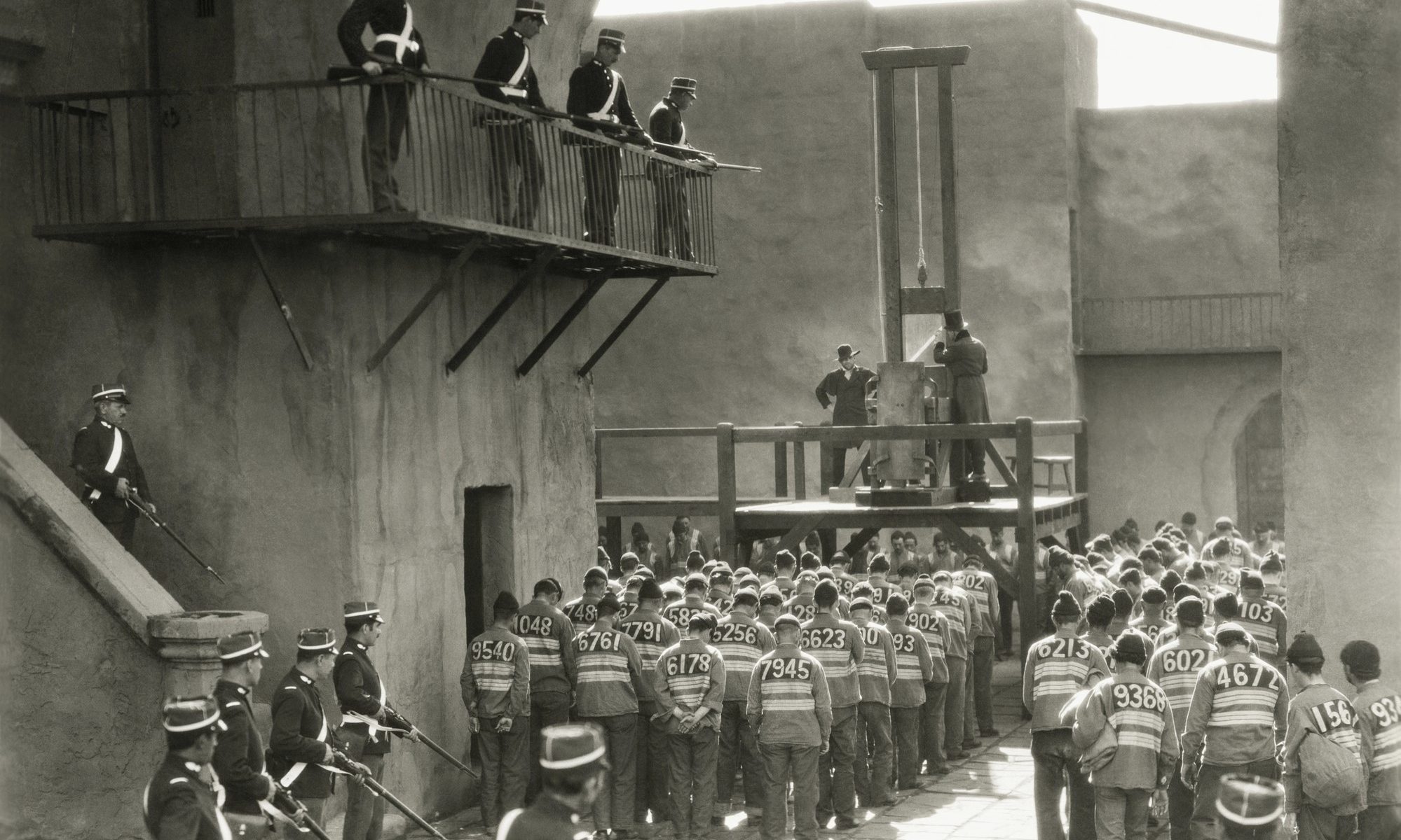 black and white photograph of prisoners preparing for guillotine