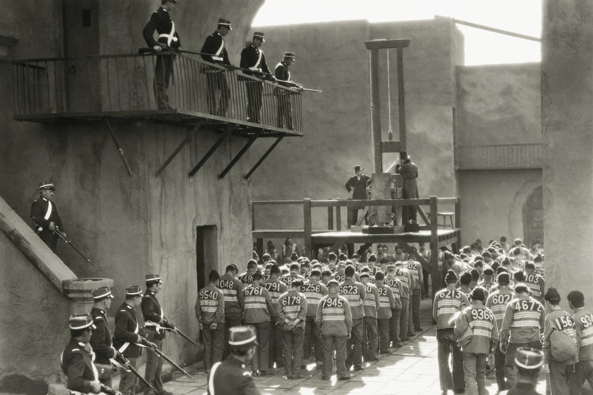 black and white photograph of prisoners preparing for guillotine