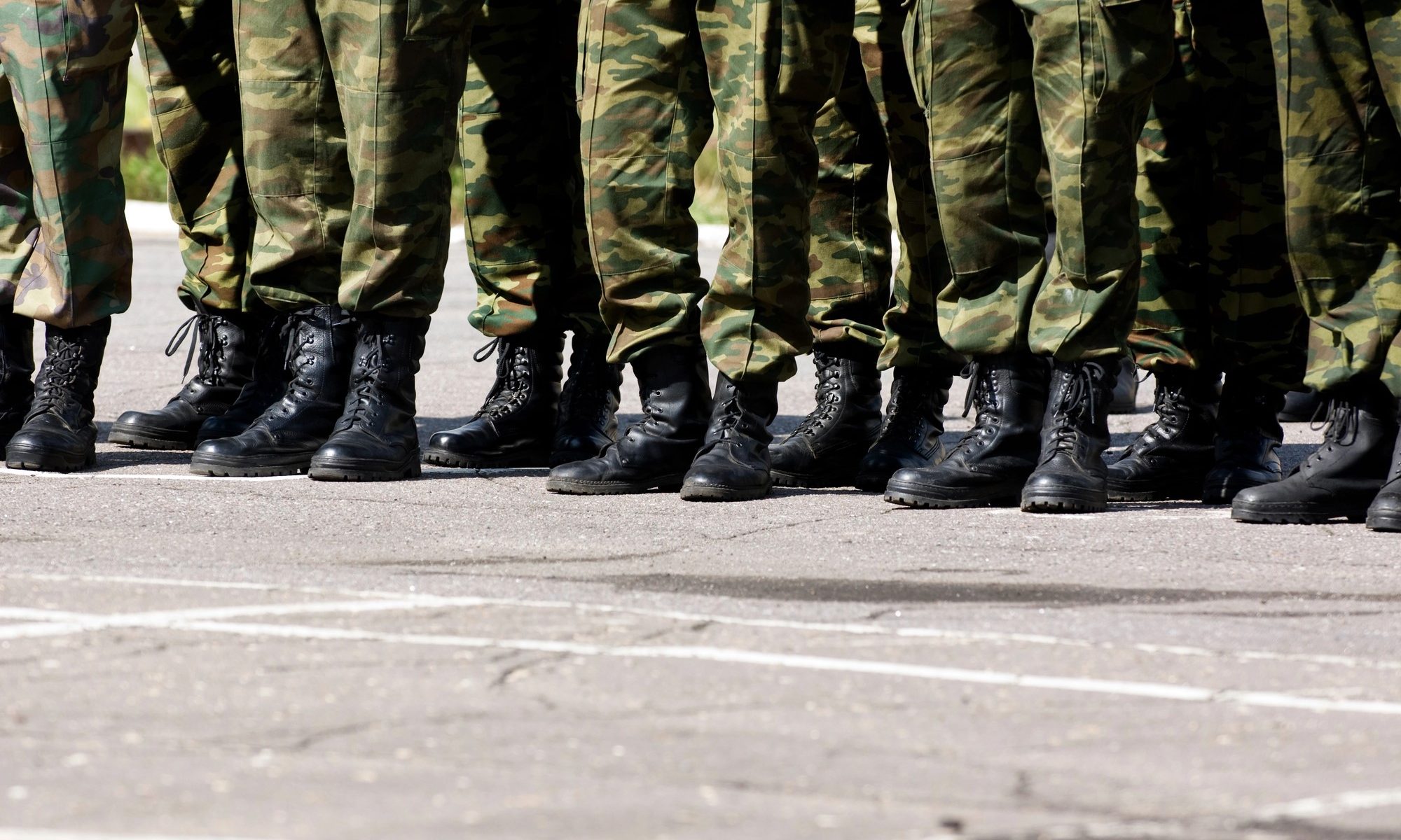 photograph of military boots and fatigues standing in line