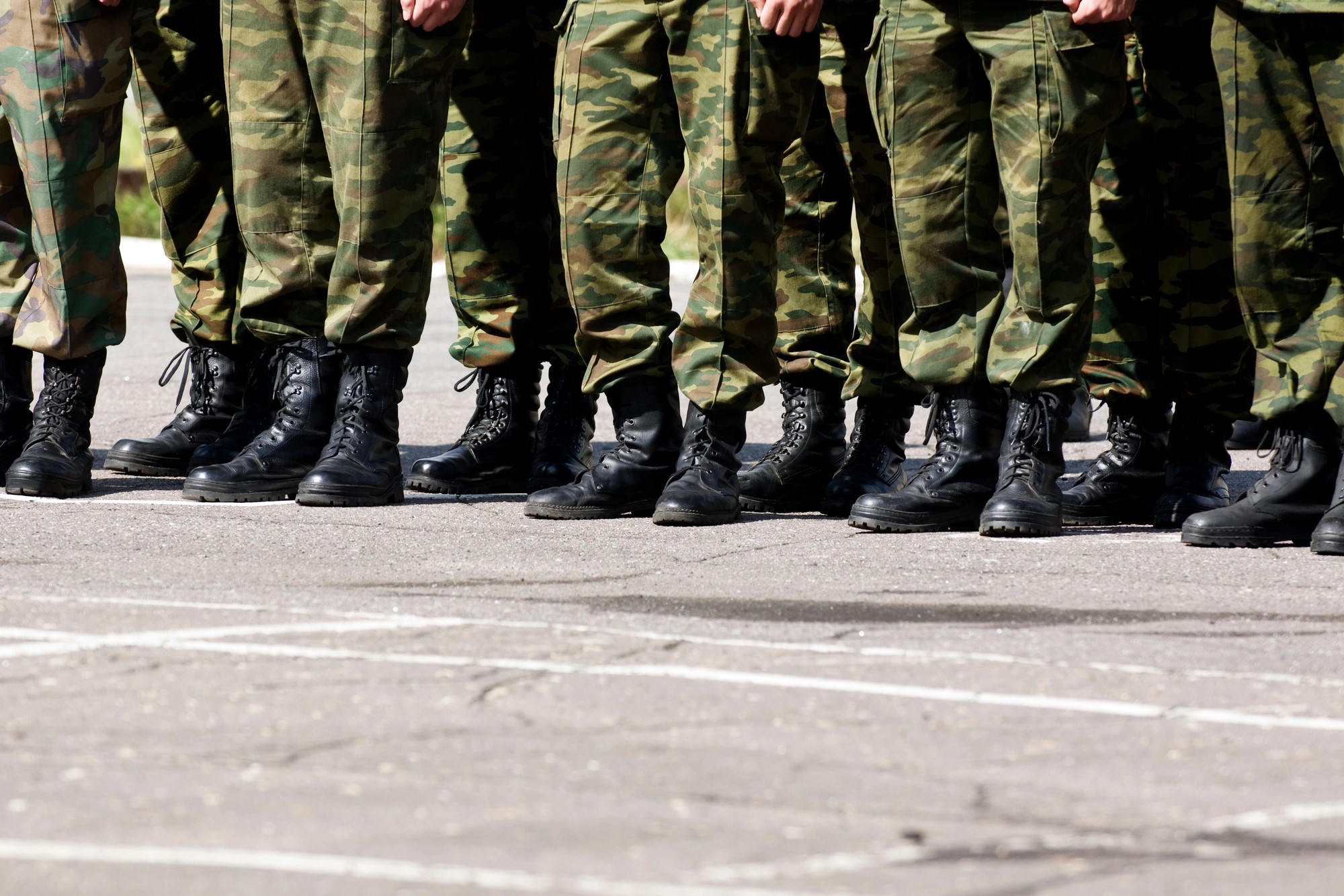 photograph of military boots and fatigues standing in line